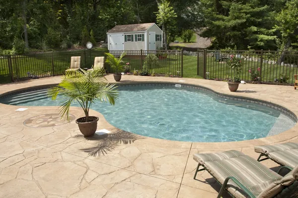 Stamped concrete pool deck around a backyard pool