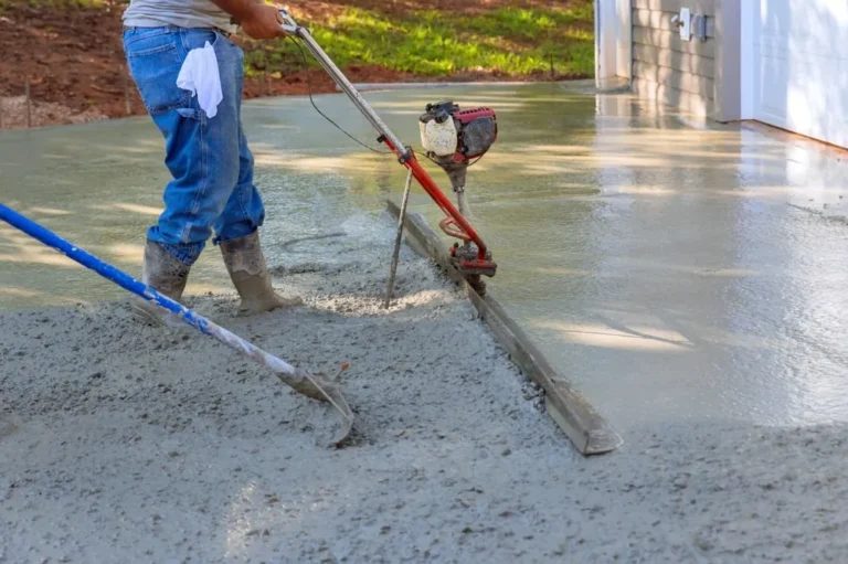Contractor using a power trowel on a driveway