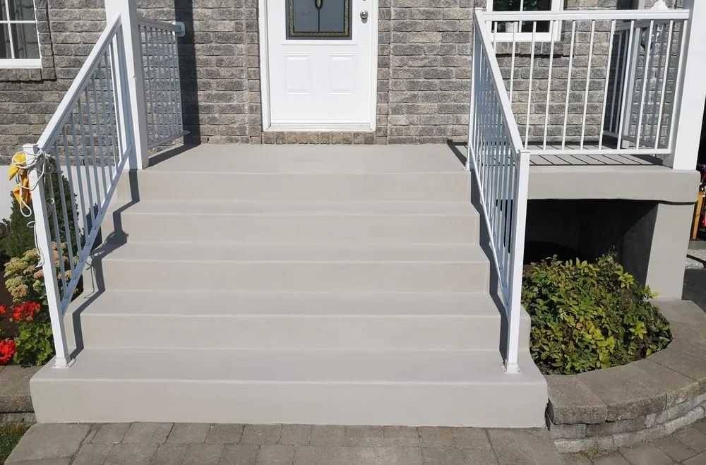 Freshly formed concrete front steps with railings