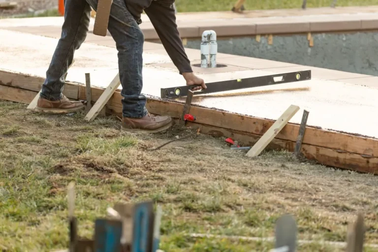 Contractor levelling the concrete around a pool
